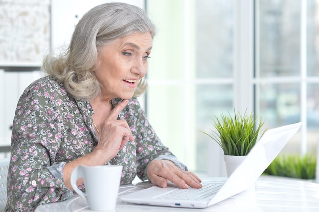 Mujer senior emocional con laptop