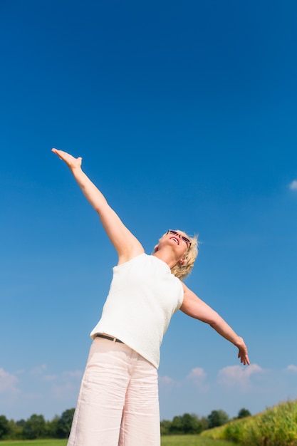 Mujer senior en forma mirando hacia el cielo mientras disfruta del retiro