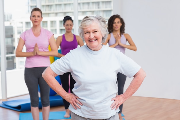 Mujer Senior con las manos en la cadera de pie en el gimnasio