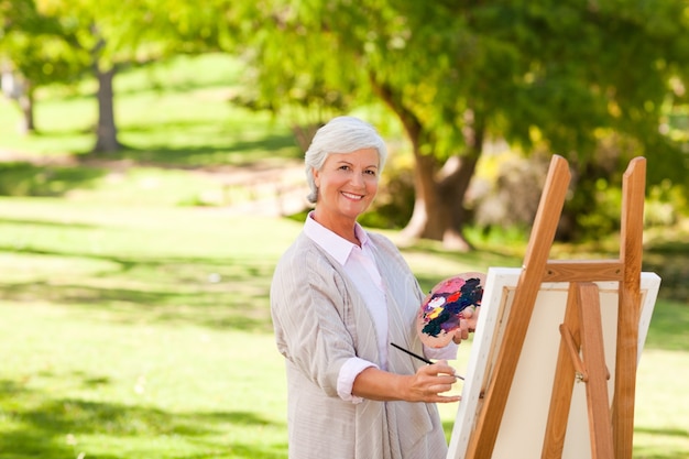 Mujer Senior pintura en el parque