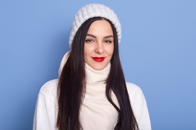 Mujer sensación de frío, vestida con gorra blanca, suéter y bufanda