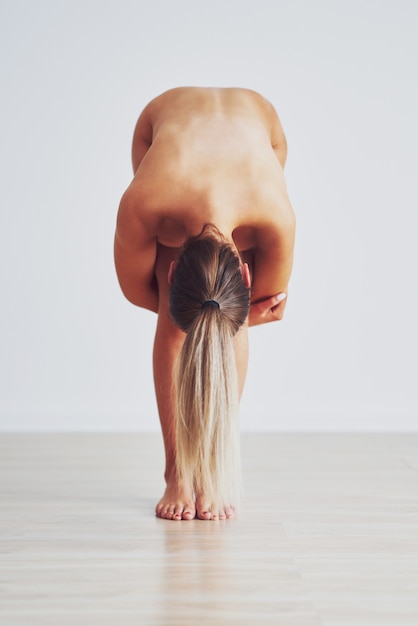mujer sensual desnuda posando sobre fondo gris