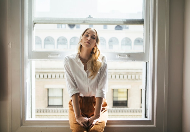 Mujer sentada en el alféizar de una ventana