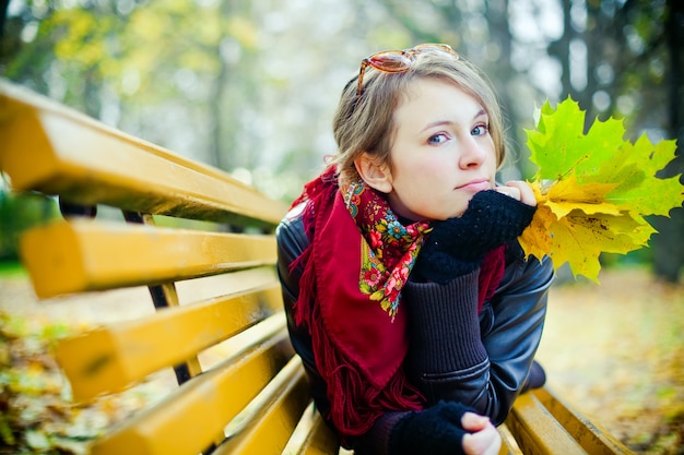 Mujer sentada en un banco, otoño humor.