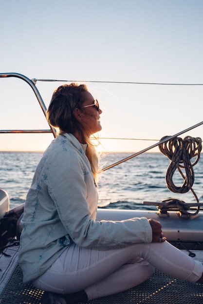 Foto mujer sentada en un barco en el mar contra el cielo