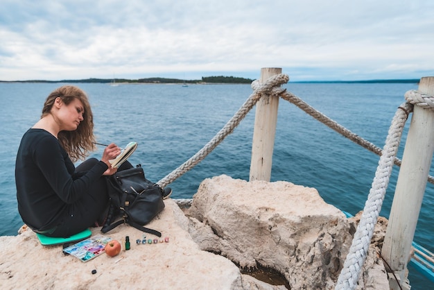 Mujer sentada en el borde dibujo de paisaje marino puente colgante