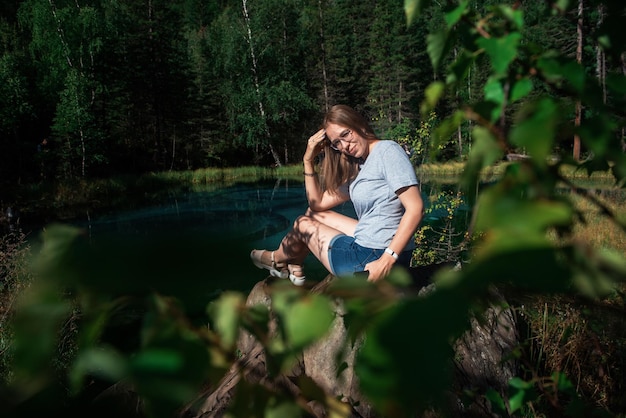 Foto mujer sentada en el bosque