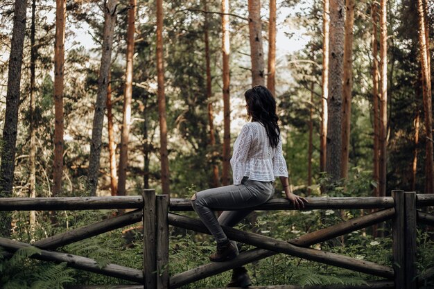 Foto mujer sentada en el bosque