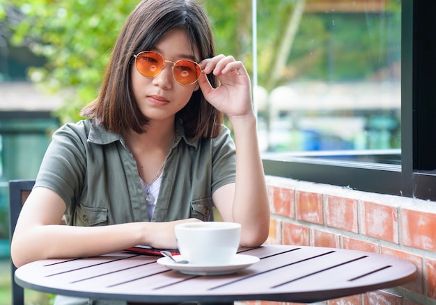 Mujer sentada en una cafetería con terraza