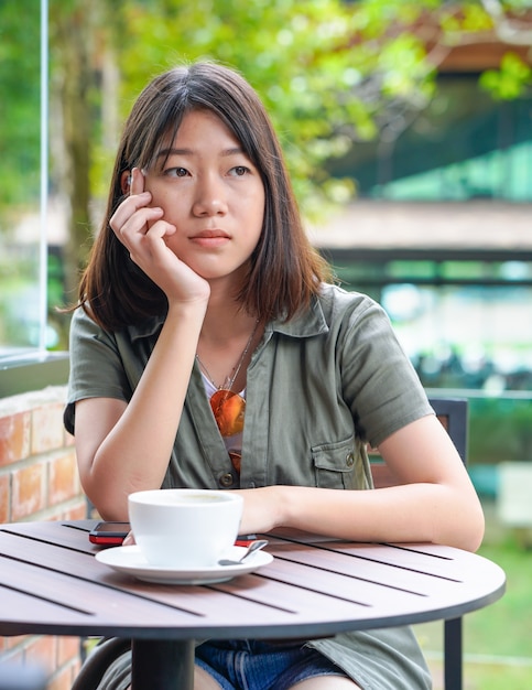 Mujer sentada en una cafetería con terraza