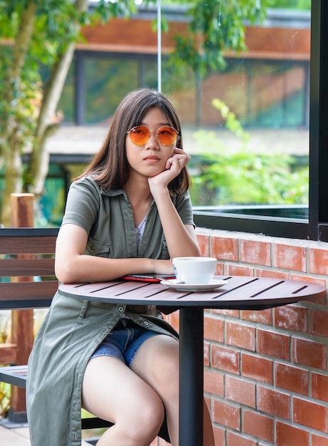 Mujer sentada en una cafetería con terraza