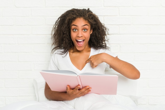 Mujer sentada en la cama con un libro