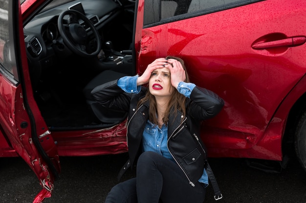 Mujer sentada en la carretera después de un accidente