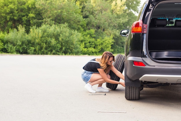 Mujer sentada en un coche por la carretera