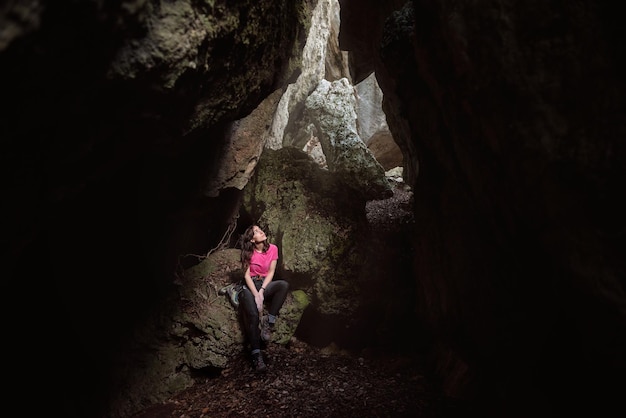 Foto mujer sentada en una cueva