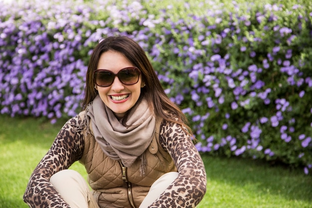 Mujer sentada delante de un árbol de lavanda.