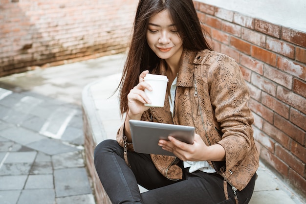 Mujer sentada y disfrutando de un café mientras trabajaba al aire libre