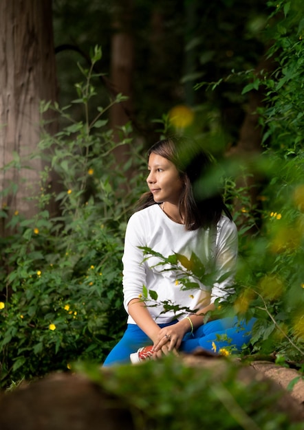 Mujer sentada en bosque encantado