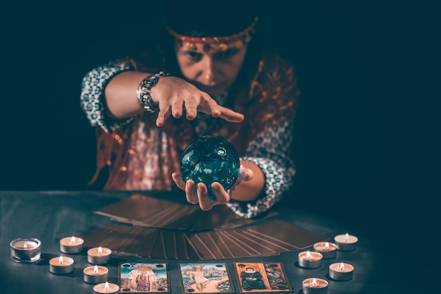 Foto mujer sentada con equipos de iluminación iluminados en la mesa contra un fondo gris