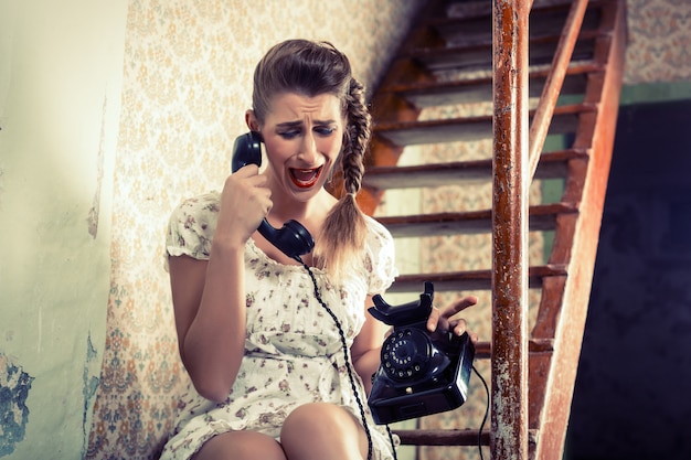 Mujer sentada en las escaleras y llorando por teléfono