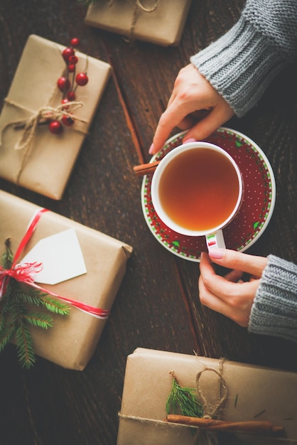 Mujer sentada en el escritorio con caja de regalo de navidad