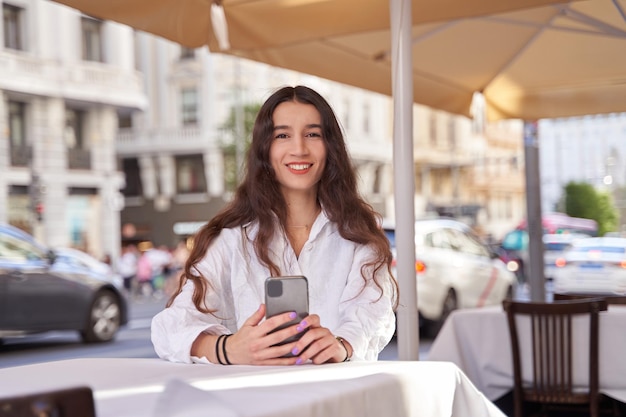 Mujer sentada esperando en la mesa en el café restaurante al aire libre