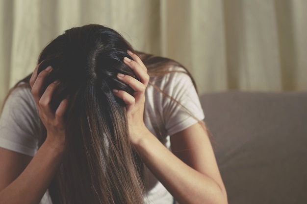 Una mujer sentada estresada, deprimida, con insomnio que rompió con su novio.