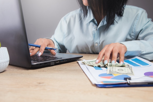 Mujer sentada frente a su mesa de trabajo estudiando documentos y datos