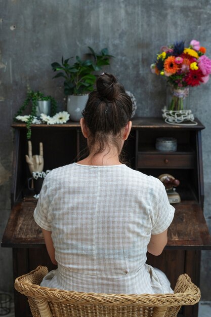 Mujer sentada junto a un antiguo escritorio de madera