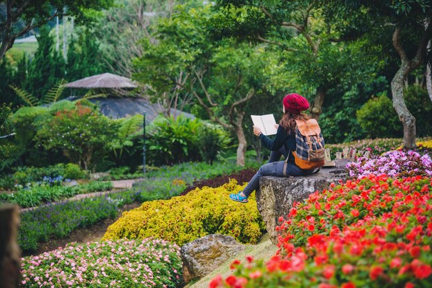 Foto mujer sentada junto a las plantas con flores