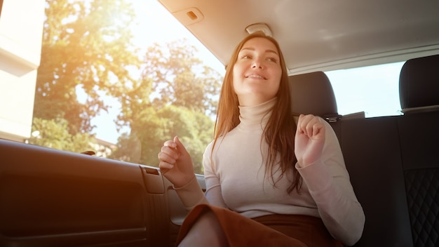 Mujer sentada en limusina y bailes disfrutando de viajar