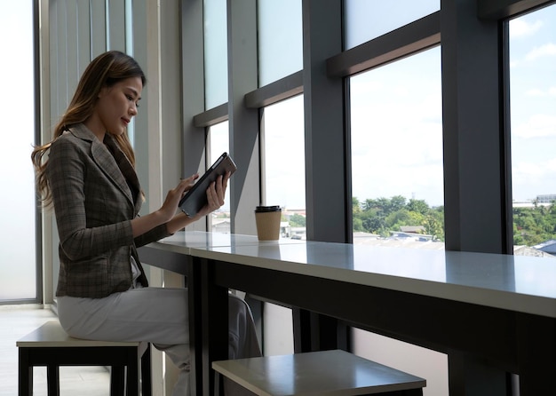 Una mujer sentada en una mesa leyendo un libro en un café.