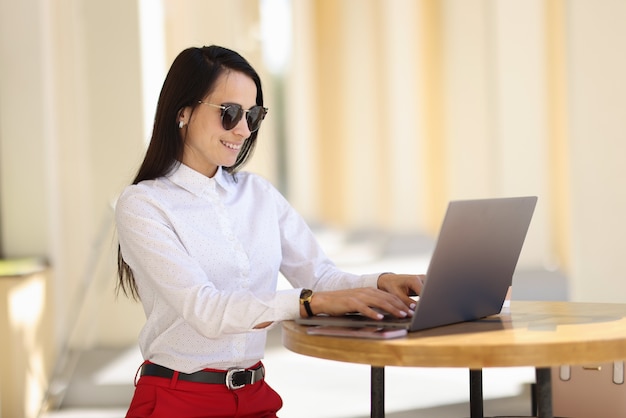 Mujer sentada a la mesa con portátil