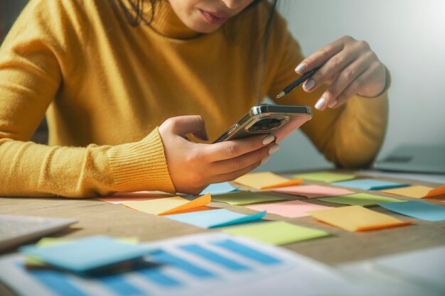 una mujer sentada en una mesa con un teléfono celular