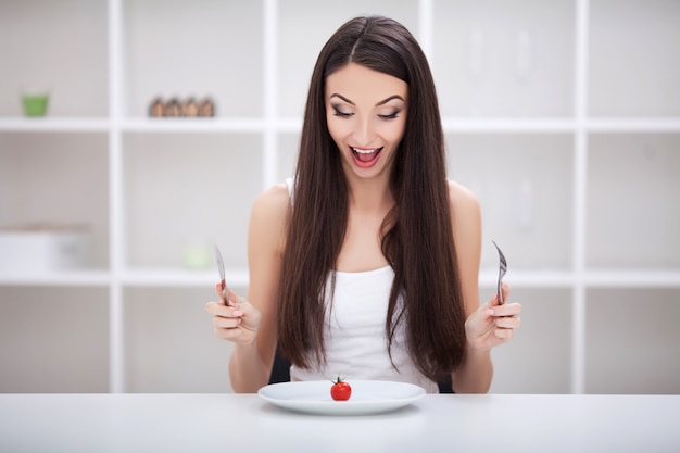 Mujer sentada en una mesa con verduras en un plato