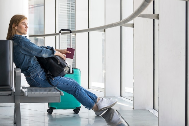 Foto mujer sentada mientras espera avión