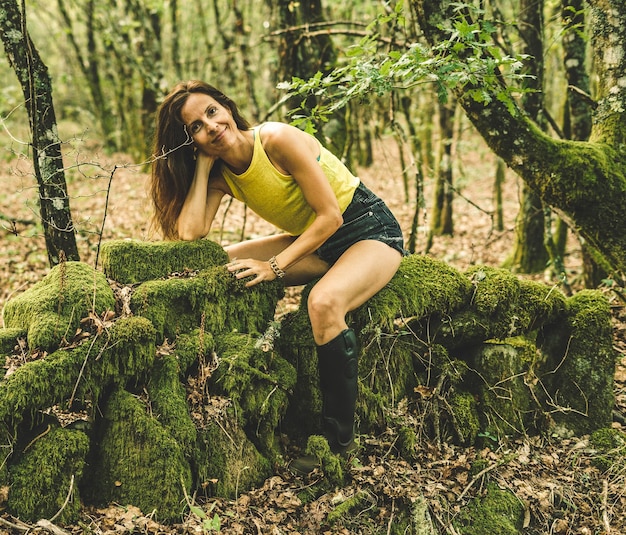 Foto mujer sentada en una pared