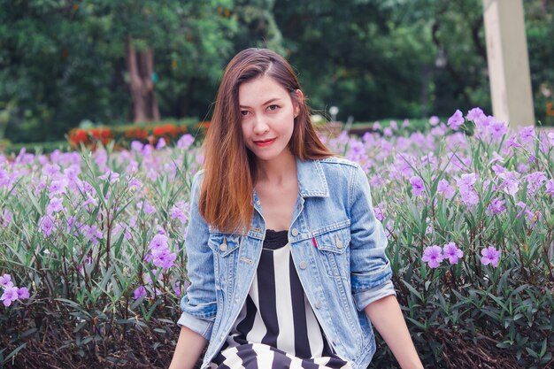 Mujer sentada en un parque donde las flores florecen maravillosamente.