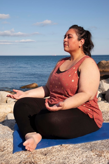 Mujer sentada en la playa frente al mar