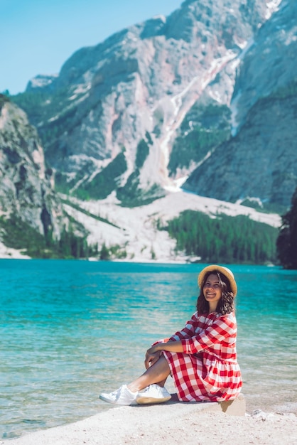 Mujer sentada en la playa de la temporada de verano del lago de montaña