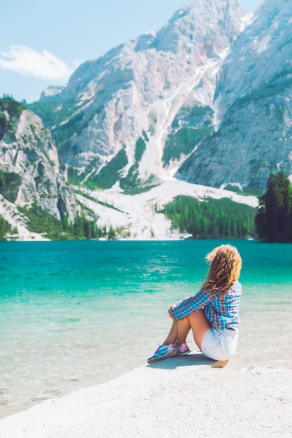 Mujer sentada en la playa de la temporada de verano del lago de montaña