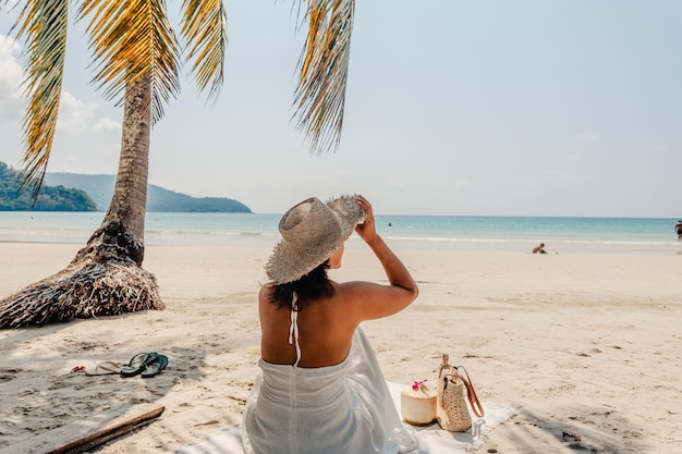 Mujer sentada relajándose en la arena de la playa