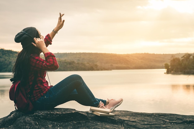 Foto mujer sentada en una roca sentada contra el cielo