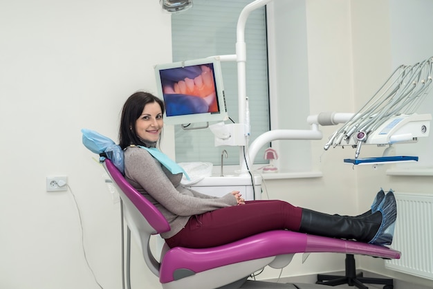 Mujer sentada en la silla del dentista y esperando a un médico