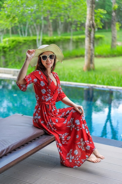 mujer sentada en la silla junto a la piscina