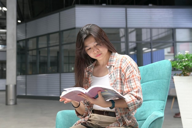 Mujer sentada en una silla y leyendo un libro