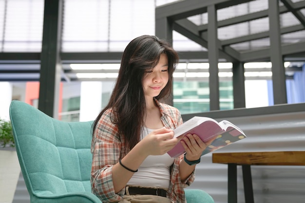 Mujer sentada en una silla y leyendo un libro