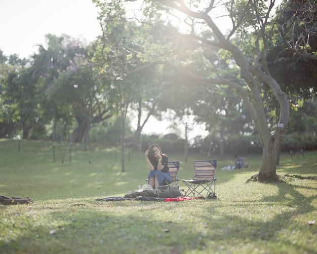 Foto mujer sentada en una silla en el parque