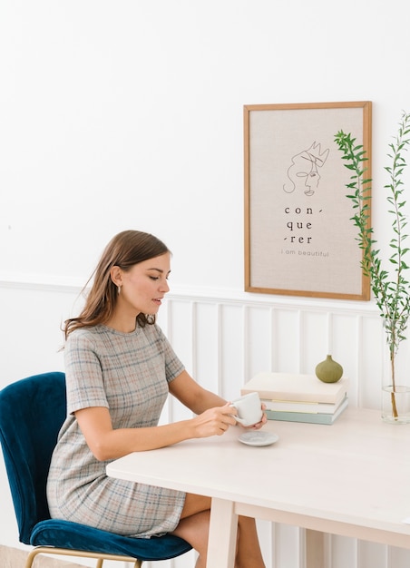 Mujer sentada en una silla sosteniendo la taza de café