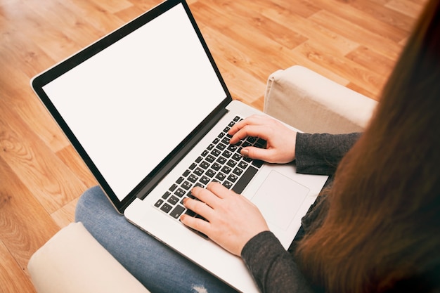 Mujer sentada en una silla y trabajando en la computadora portátil